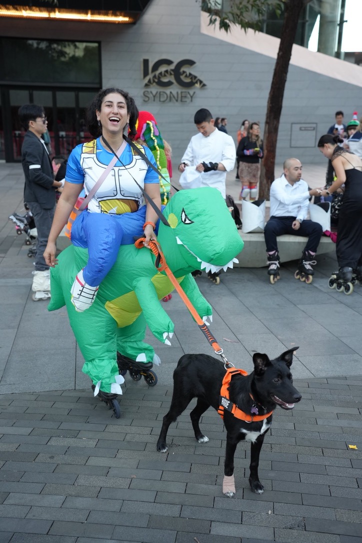 Laura in a dinosaur costume on skates with Rogue at the Halloween skate